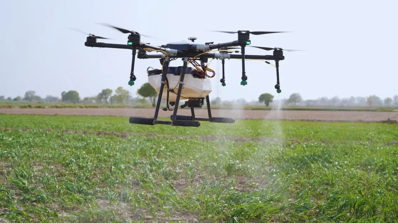 Agricultural drone spraying over a green field