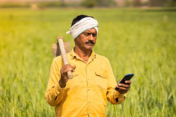 Farmer holding a phone showing the FarmJaan app