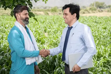 Farmer and vendor shaking hands in a golden field